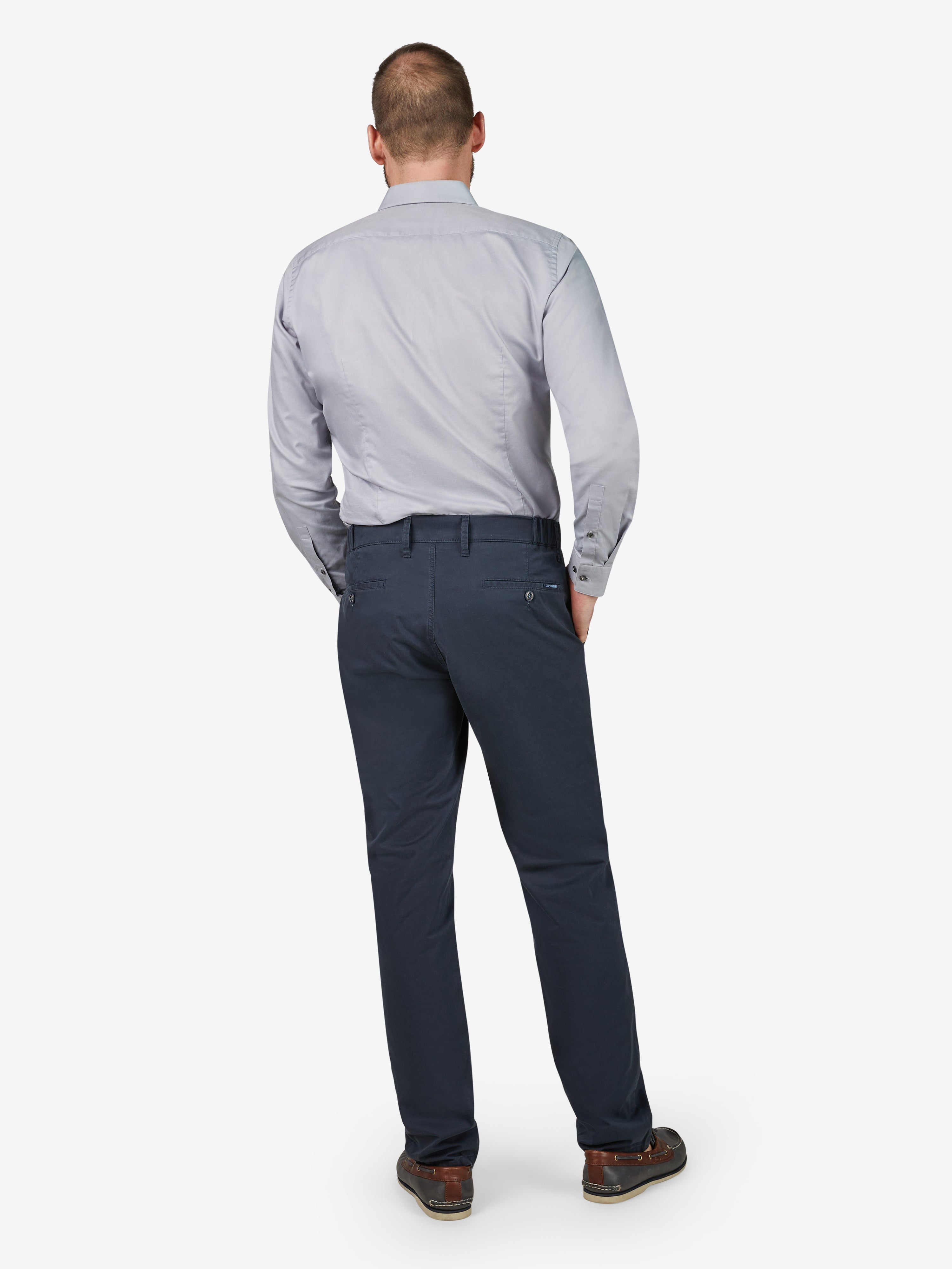 Ein Mann trägt eine marineblaue Chino-Hose mit Slim Fit, hergestellt aus sommerleichter, elastischer Baumwolle mit Comfort-Flex-Bund und Hemdenstopper, passend für Frühling/Sommer, produziert von Club of Comfort.