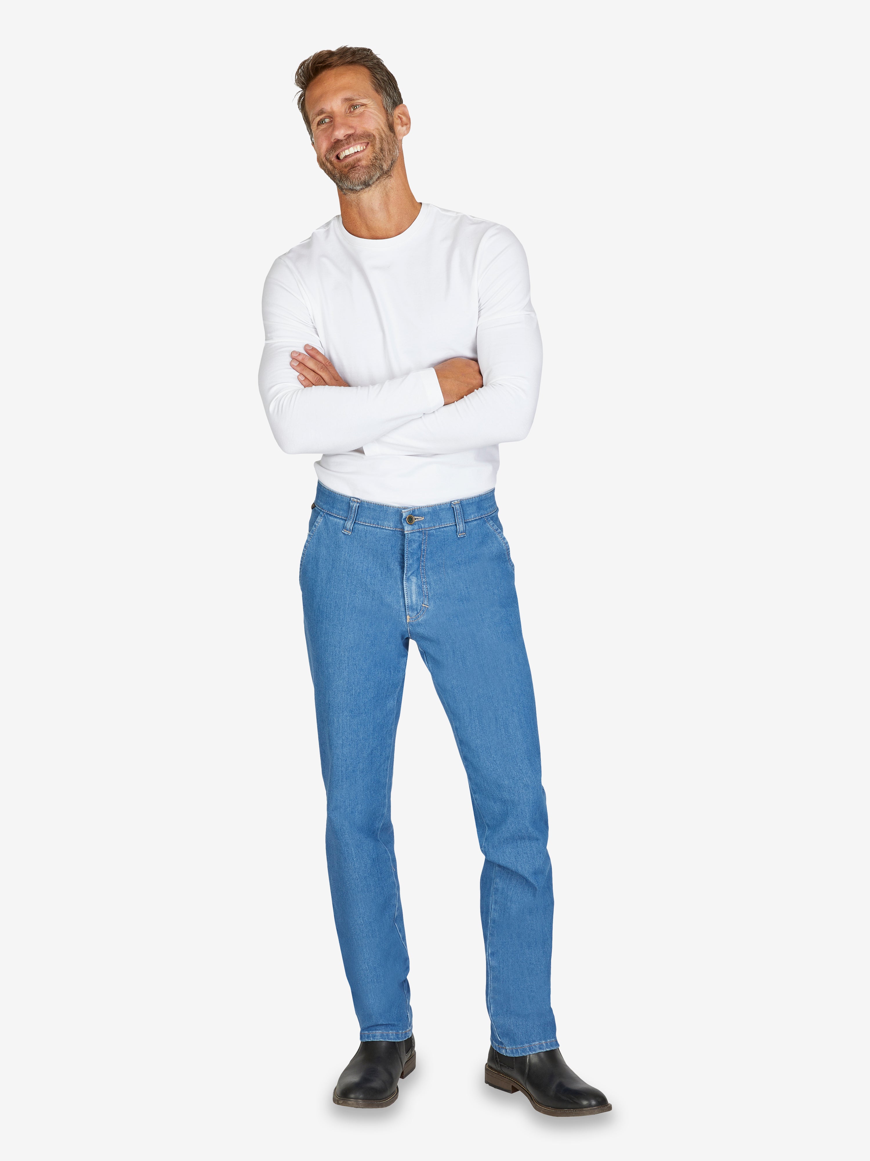 Mann trägt eine helle Jeansblau GARVEY 7054 Flat Front-Hose mit elastischem Komfortbund, Hemdstopper und Münztasche. Kombination aus superelastischem Bi-Stretch-Denim, schmaler Beinverlauf, normaler Leibhöhe und bequemer Passform, ideal für ganzjährige Nutzung.