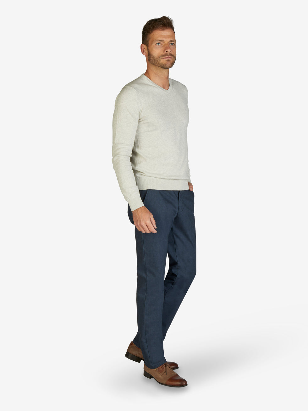 Mann in weißem Pullover und blauer GARVEY 7827 Flat Front-Hose mit elastischem Komfortbund, Hemdenstopper und Thermolite-Wärmeisolierung, perfekt für Herbst/Winter, Regular Fit, aus Baumwolle mit Mikrostruktur im Wool Look.