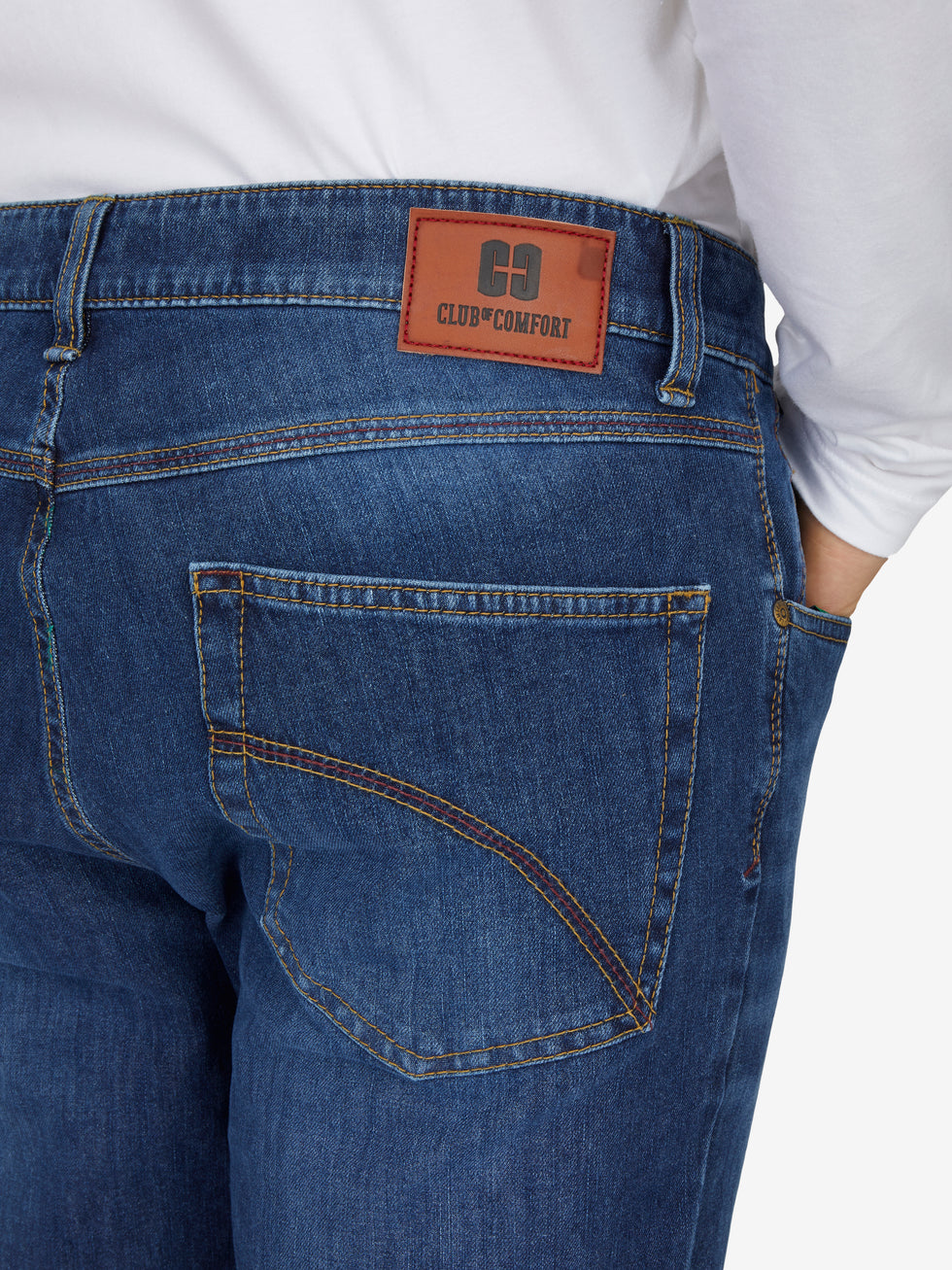 Nahaufnahme einer blauen, gewaschenen 6-Pocket-Hose von Club of Comfort mit elastischem Doppelstoffbund, Hemdstopper, separater "Mobile Pocket" für Smartphone, made aus superelastischem Bi-Stretch-Denim, reguläre Leibhöhe, schlankes Bein, sichtbar am Rücken mit Markenlabel "CLUB COMFORT".