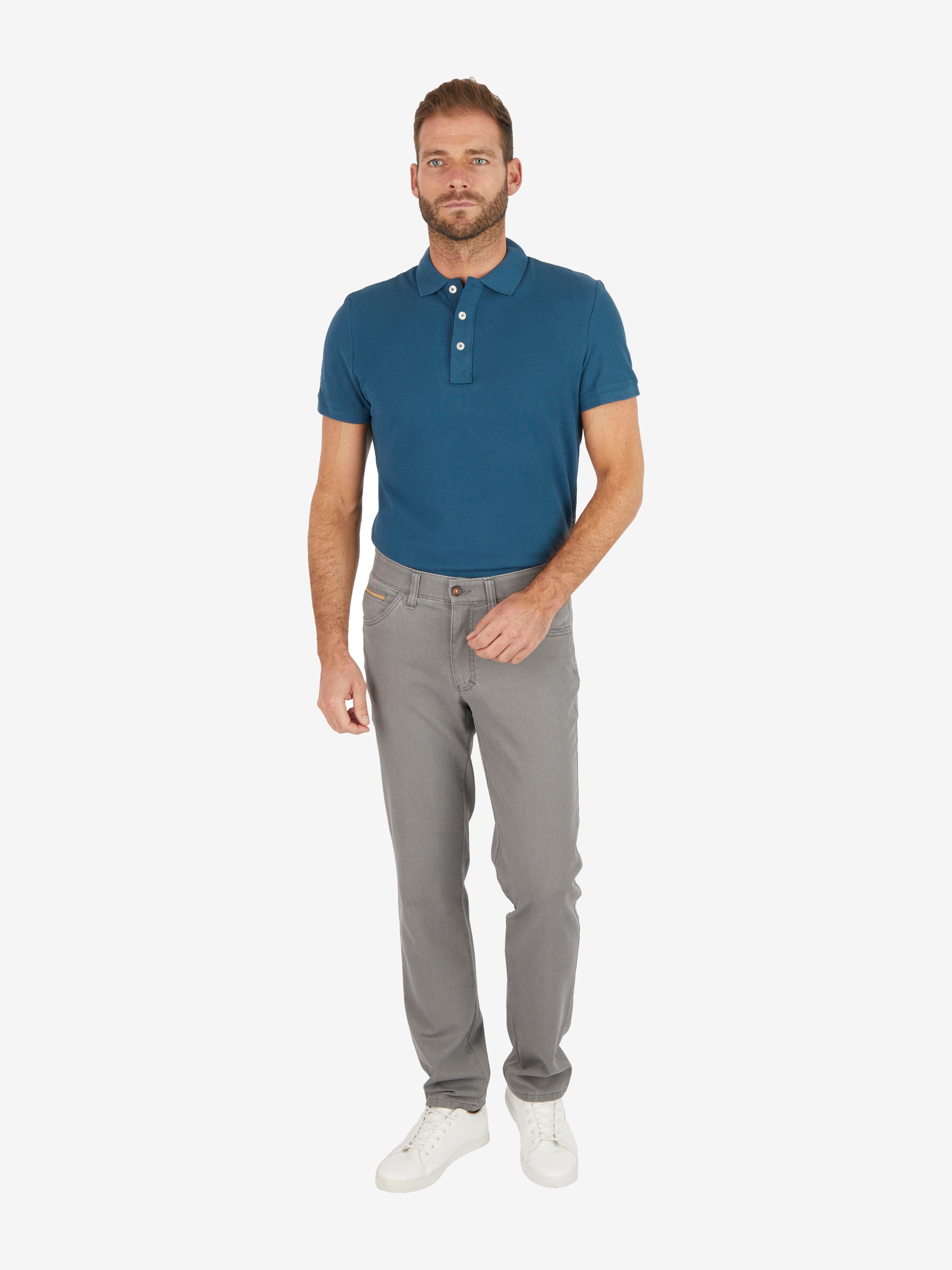 Männlicher Model trägt eine graue, modifizierte 5-Pocket Hose des Herstellers Club of Comfort mit High Stretch-Baumwolle, Comfortbund und Hemdenstopper, kombiniert mit einem blauen Polohemd. Die Hose hat einen Regular Fit, eine hohe Bewegungsfreiheit, Schmaler Beinabschluss, hergestellt aus nachhaltiger Baumwolle, geeignet für Frühjahr/Sommer.