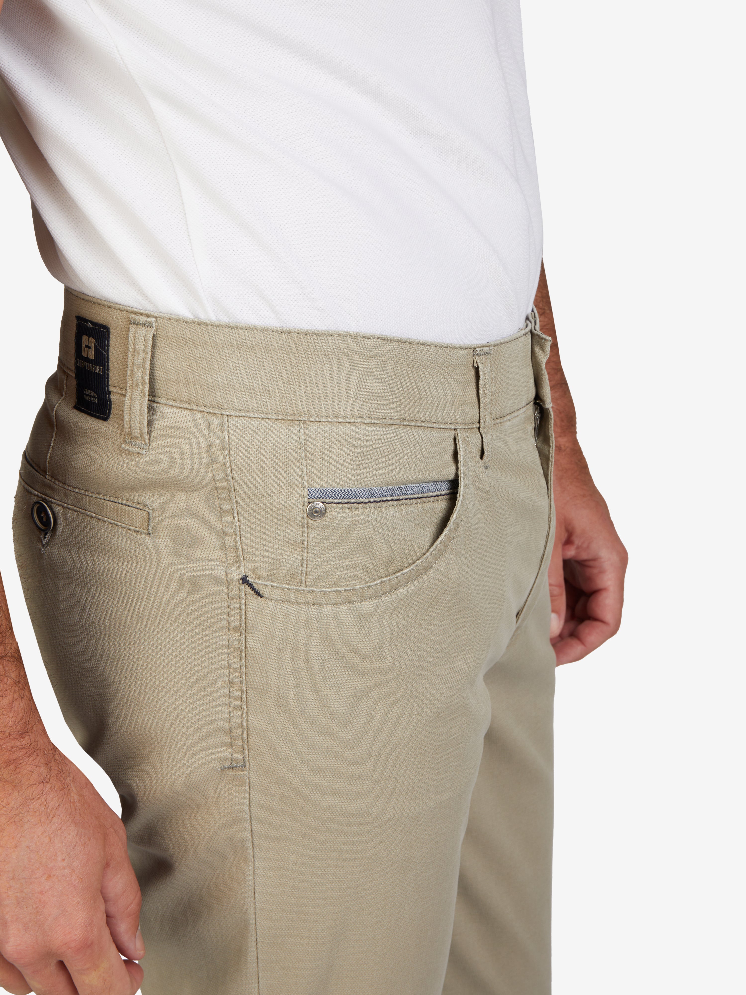 Vedsideansicht einer graugelben Herren-Hose von Club of Comfort, Modell MARVIN 7907, mit elastischem Comfortbund, Swing-Pockets, Kontrast-Münztasche, aus hoch elastischer High Stretch-Baumwolle, normale Leibhöhe, schmalem Bein und schmaler Fußweite, geeignet für Frühling/Sommer, waschbar, Made in Green by Oeko-Tex.