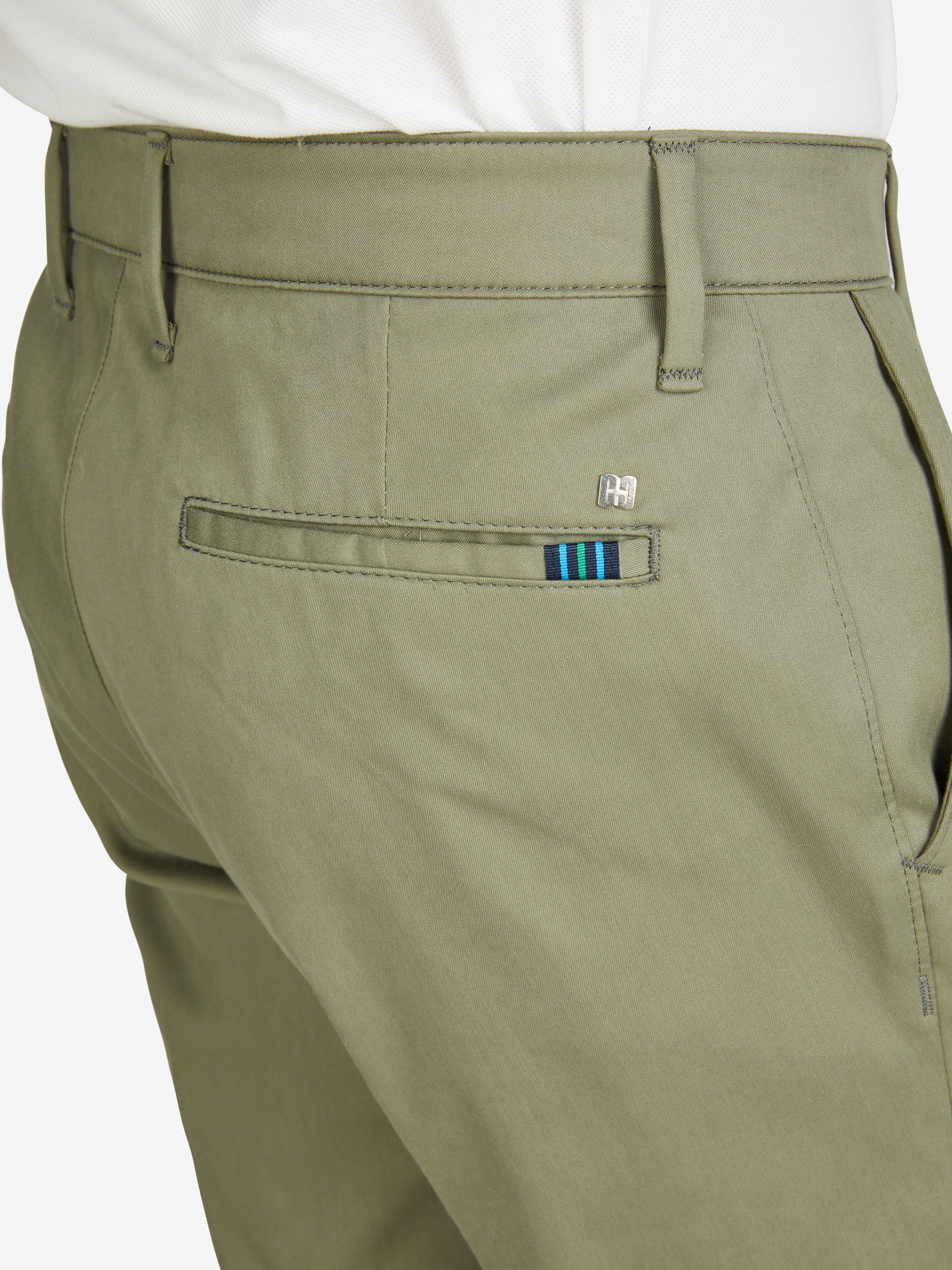 Nahaufnahme einer Khaki-farbenen Chinohose vom Hersteller Club of Comfort, Modell ROB 8130, mit elastischem Komfortbund, Hemdenstopper und Tapered Fit. Die Hose besteht aus High Stretch Techno-Cotton, wiegt 320 g/m, hat eine normale Leibhöhe, mehr Platz im Gesäß und Oberschenkel, schmalen Beinverlauf und ist ganzjahrestauglich.