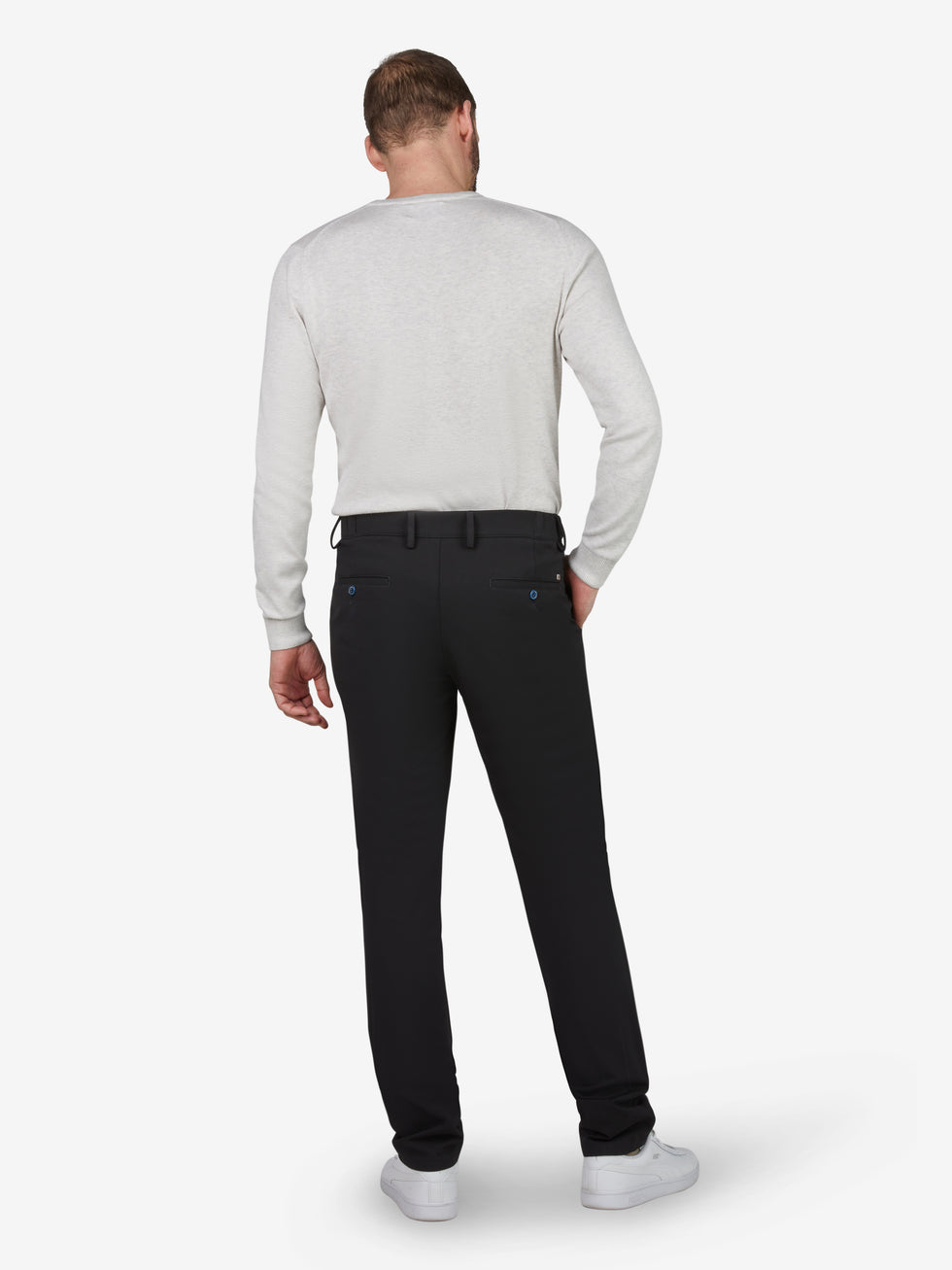 Herrenmodel trägt schwarze FOXX 8240 Chino-Hose in Slim Fit mit mittlerer Leibhöhe, elastischem Smokbund und Hemdstopper, gefertigt aus hochelastischem Polyamid-Viskose-Mix mit Microstruktur, bequem auch in Ganzjahresnutzung, seitlich eingepasst mit Mobiltelefon-Tasche, EU-Größe, auf weißem Hintergrund.