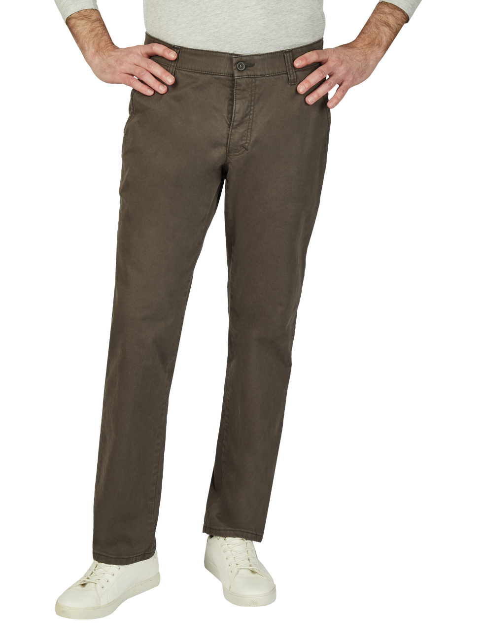 Blick auf die unteren Körperhälfte eines Mannes, der eine graue Strickjacke, braune Hosen und weiße Sneakers trägt. Die Person hat die Hände auf die Hüften gelegt.
