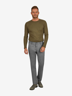 Mann trägt eine graue GARVEY 7708 Flat Front-Hose aus Baumwoll-High Stretch mit elastischem Komfortbund, Hemdenstopper und normaler Leibhöhe, kombiniert mit einem grünen Langarmshirt.