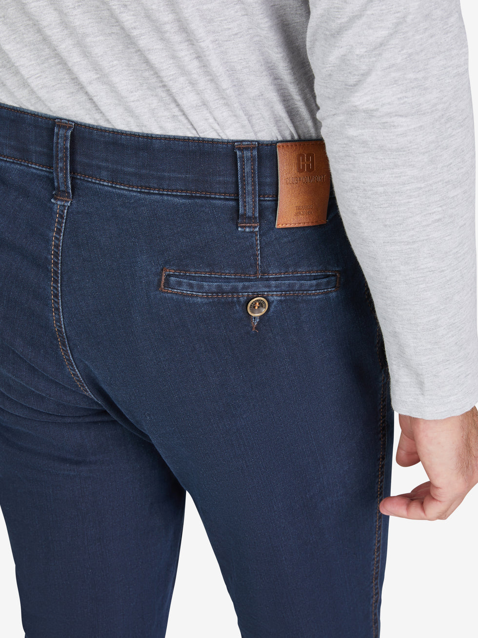 Nahaufnahme einer dunkelblauen GARVEY 7915 Flat Front-Hose mit elastischem Komfortbund, Hemdstopper und praktischer Bundverlängerung mit Knopf und Haken. Die Hose ist aus hoch elastischem Super High Stretch-Denim gefertigt, mit schmaler Beinweite, normaler Leibhöhe und sichtbarem grauem Oberteil.