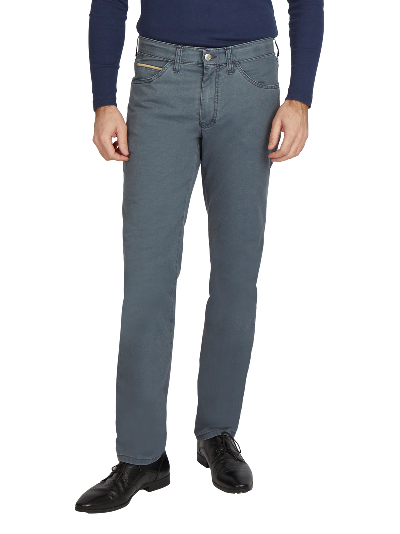 Ein Mann trägt eine dunkelblaue, lange ärmige Pullover und eine hellgraue Jeans mit geradem Schnitt, die bis zu den Hüften reicht. Die Jeans hat fünf Gürtelschlaufen, eine klassische Taschenanordnung vorne mit Münztasche und goldenen Nieten. Er trägt schwarze Lederschuhe mit Schnürung.