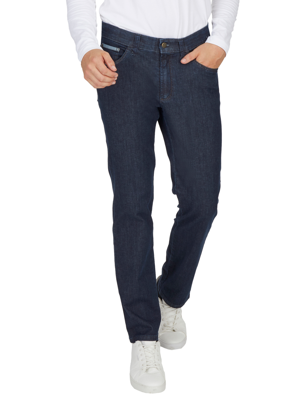Hosenmodell aus dunkelblauem Denim, getragen von einer Person, die eine weiße Bluse und weiße Sneakers trägt. Die Person hat eine Hand in der Tasche und die andere an der Seite.