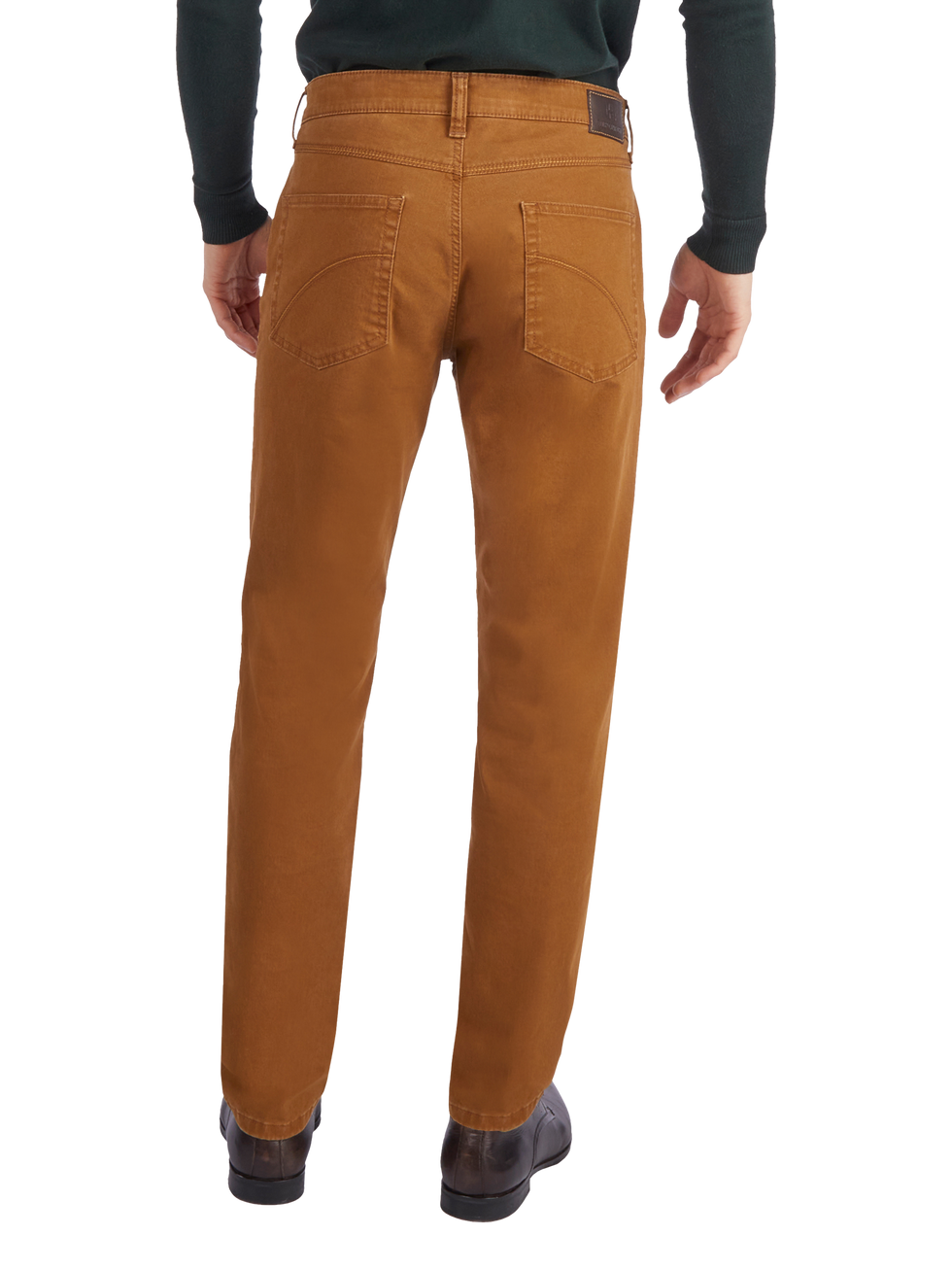 Hintere Ansicht eines Mannes, der braune Cordhosen trägt. Er trägt einen schwarzen Pullover und schwarze Schuhe. Die Hosen haben zwei hintere Taschen und einen braunen Lederaufnäher am Bund.