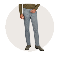 Mann trägt graue, lockere Hosen aus Baumwolle mit geradem Schnitt, breite Beinöffnung, seitlichen Eingrifftaschen und elastischen Bündchen am Saum; er steht vor neutralem Hintergrund, Oberkörper bleibt unscharf.