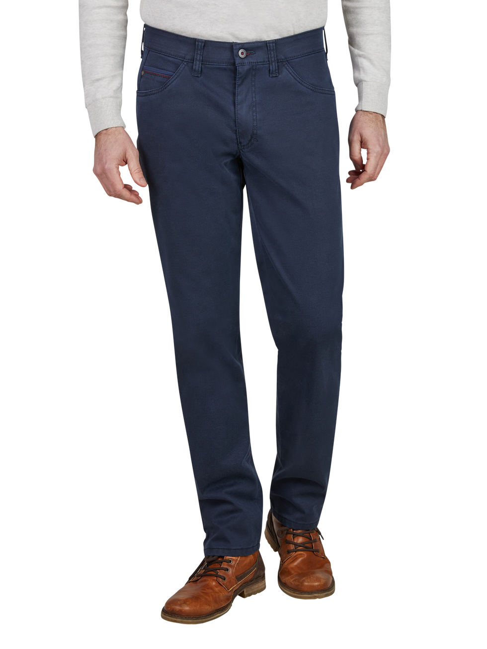 Blick auf die unteren Körperhälfte eines Mannes, der eine graue Strickjacke, dunkle Jeans, braune Lederstiefel trägt. Die Jeans sind gerade geschnitten, mit klassischen Taschen und Gürtelschlaufen.
