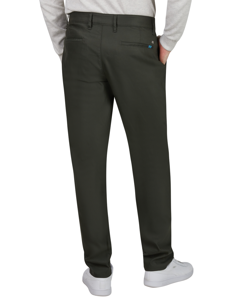 Herren trägt dunkle, schlichte Chino-Hosen, die hinten eine kleine Tasche und Gürtelschlaufen haben. Die Person trägt eine graue Langarmjacke und weiße sneakers.